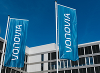 Fahnen mit dem Vonovia-Logo vor einem Bürogebäude